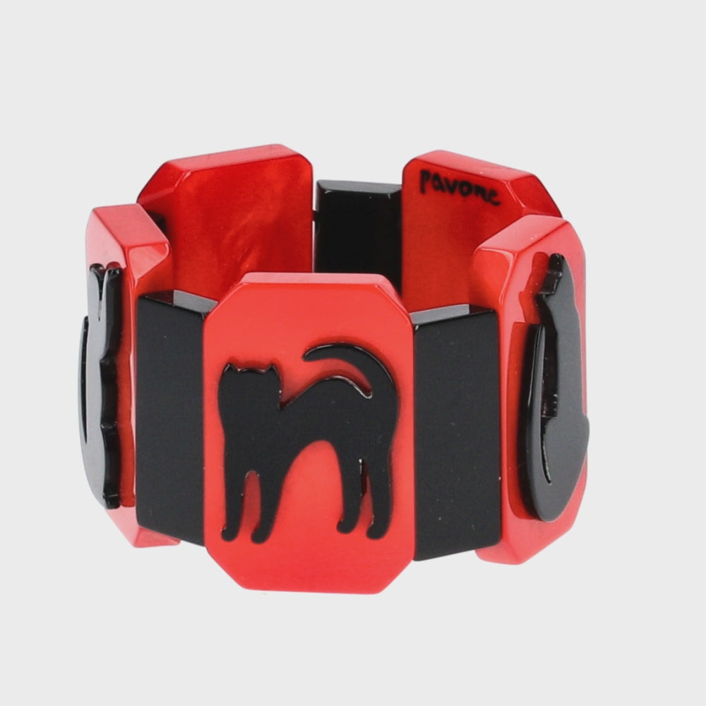 This red and black bracelet is made from galalith, a vintage material appreciated for its durability and silky appearance. Black cat silhouettes stand out against a red background. The design recalls the Art Deco style, with its clean lines and stylized motifs. It's mounted on elastic, making it easy to adapt to different wrists. Perfect for cat lovers and fans of vintage and art deco fashion.